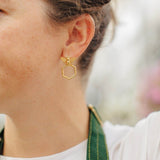 Goldbug Collection’s Beehive Hoop Earrings feature bee studs with forward-facing hexagon honeycomb hoop drops.